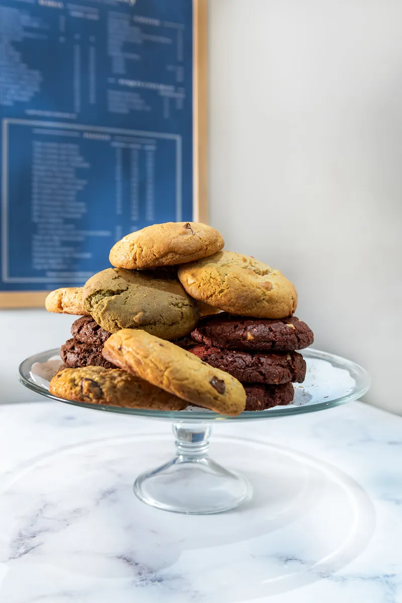 Torre de galletas estilo New York surtidas sobre pedestal de cristal